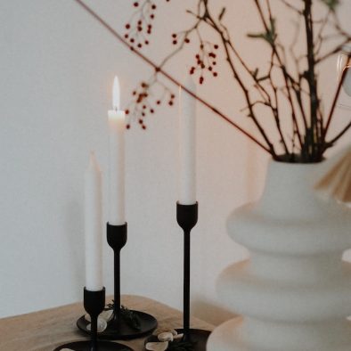 white candles on black metal candle holder